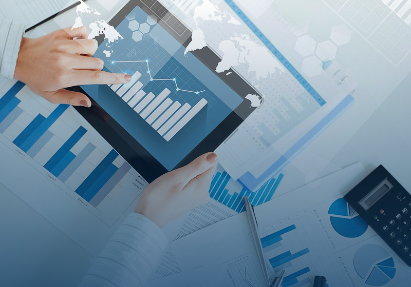 Person analyzing financial charts on a digital tablet and paper documents.