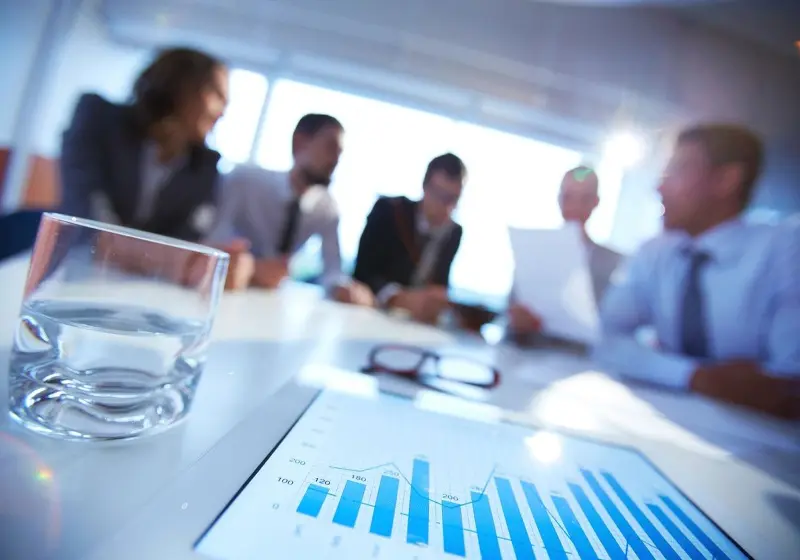Business meeting with charts and graphs in focus.