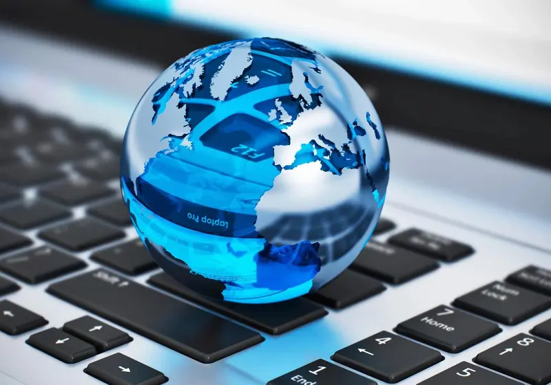 A blue glass globe on a laptop keyboard.