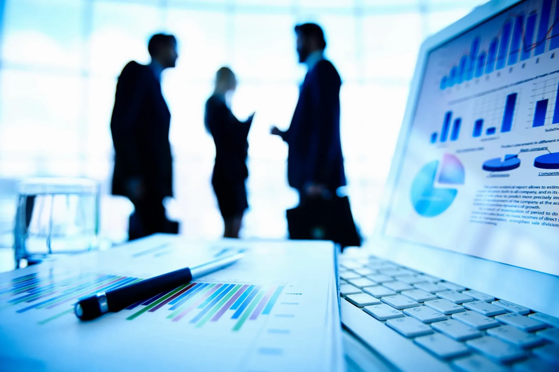 Business professionals discussing charts in a modern office.