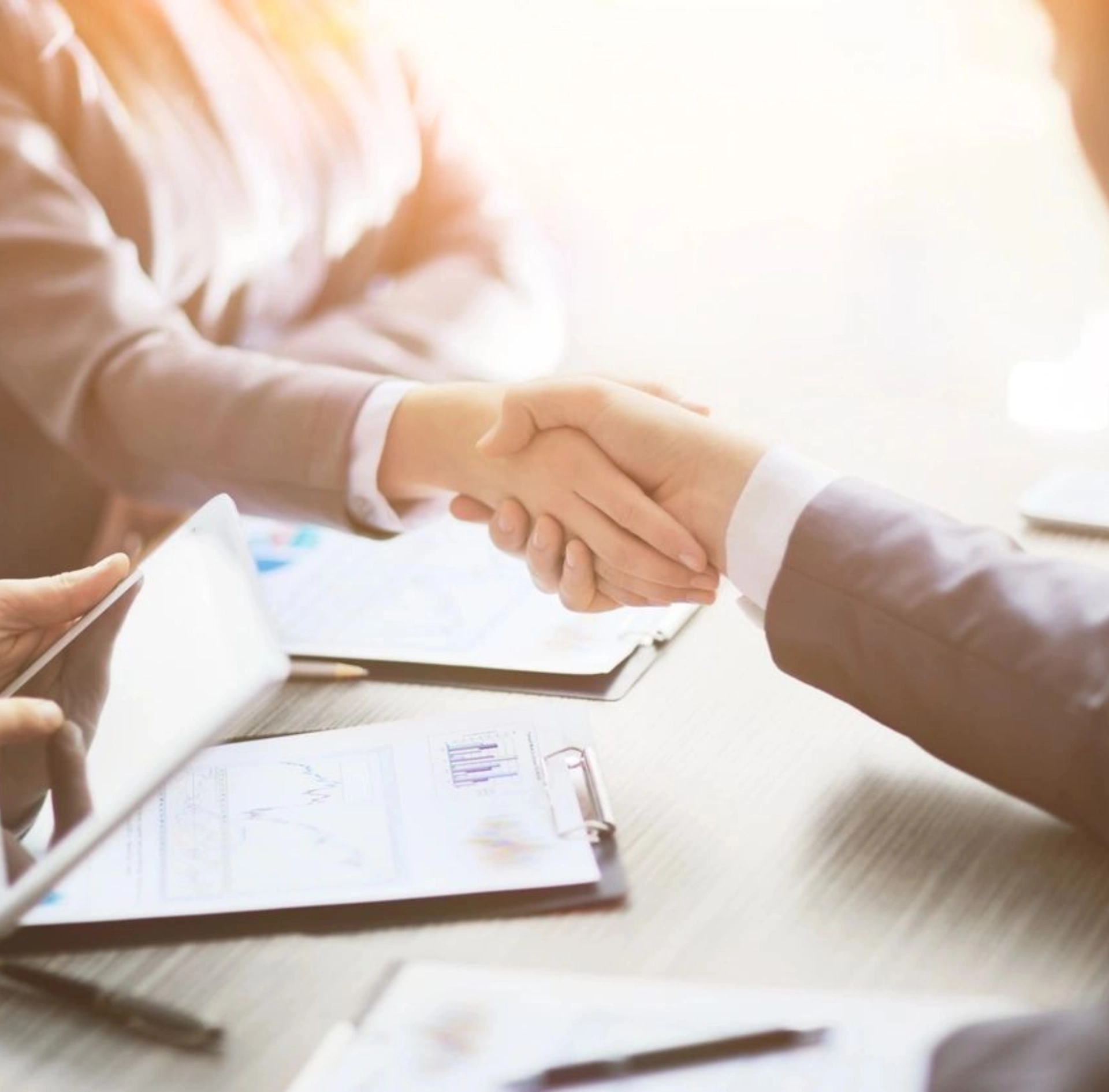 Two people shaking hands in a business setting.